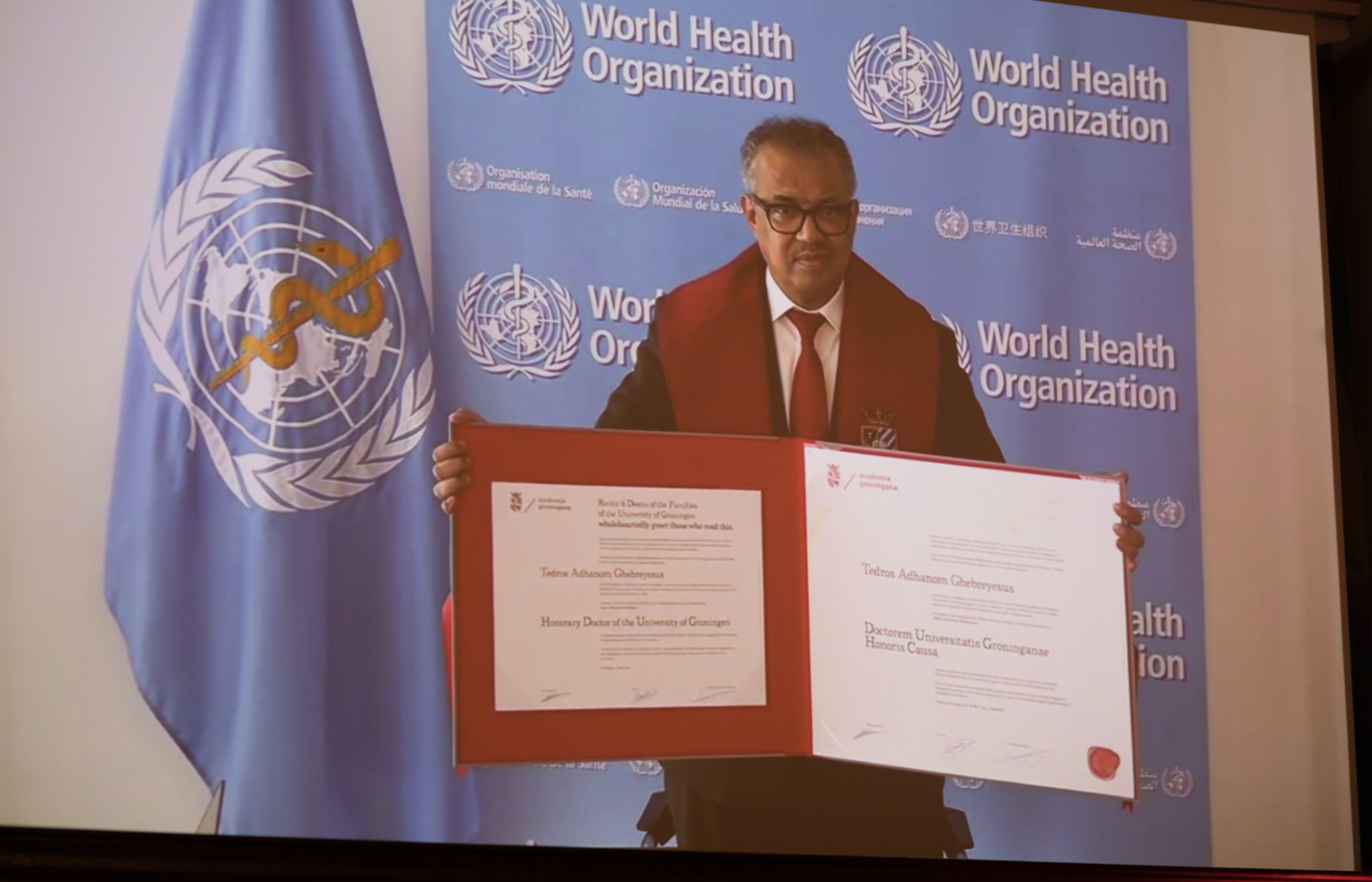 Tedros Ghebreyesus met zijn eredoctorsbul via een live-verbinding. Foto: Gerhard Taatgen